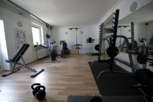 Fitnessraum mit Hantelbank, Ergometer und Hanteln